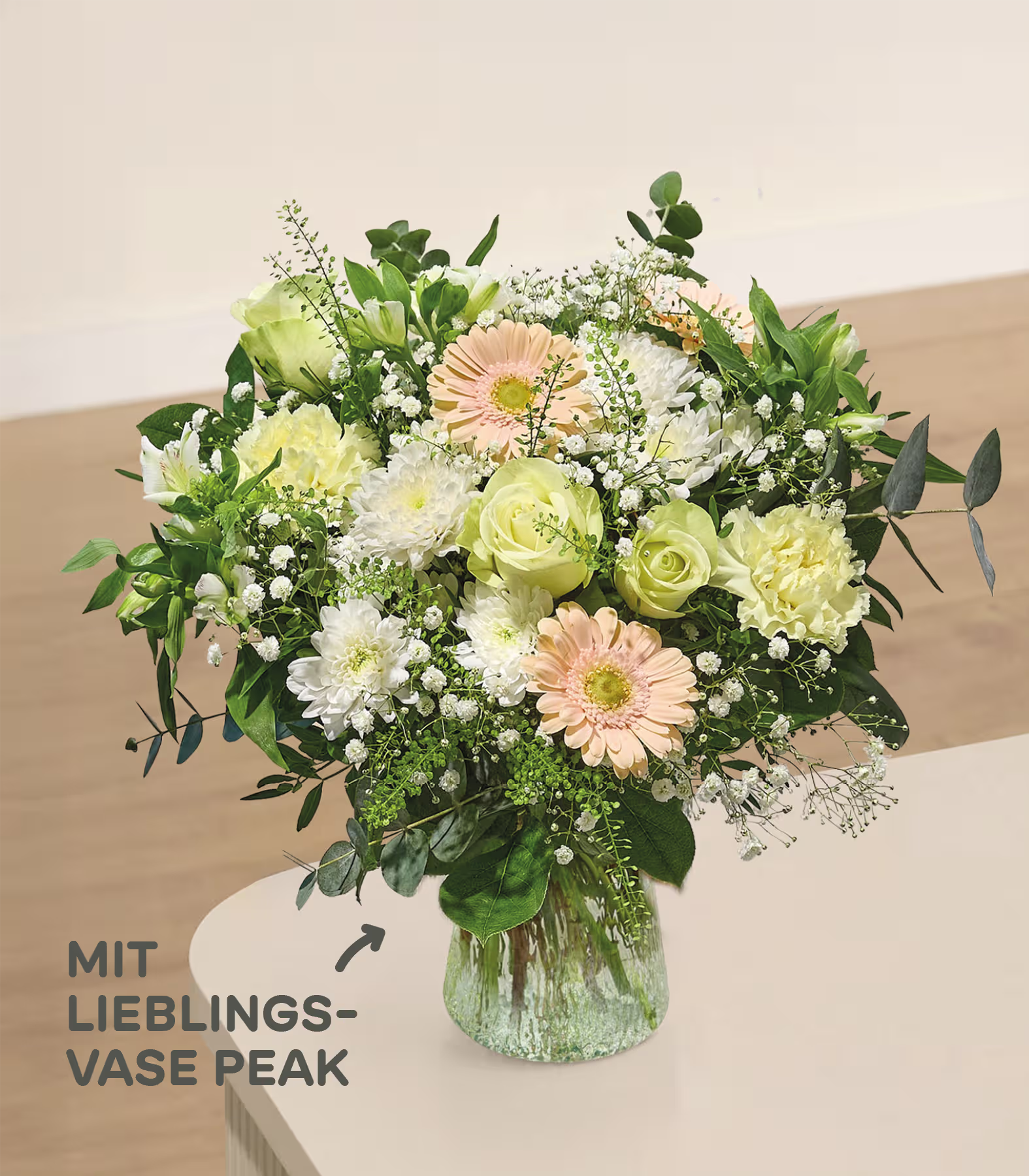 Im Vordergrund füllt ein leuchtender Strauß gelber und rosafarbener Blumen mit Schleierkraut eine strukturierte Glasvase vor einem weichen, verschwommenen Hintergrund. (Beschreibungstext KI-generiert)