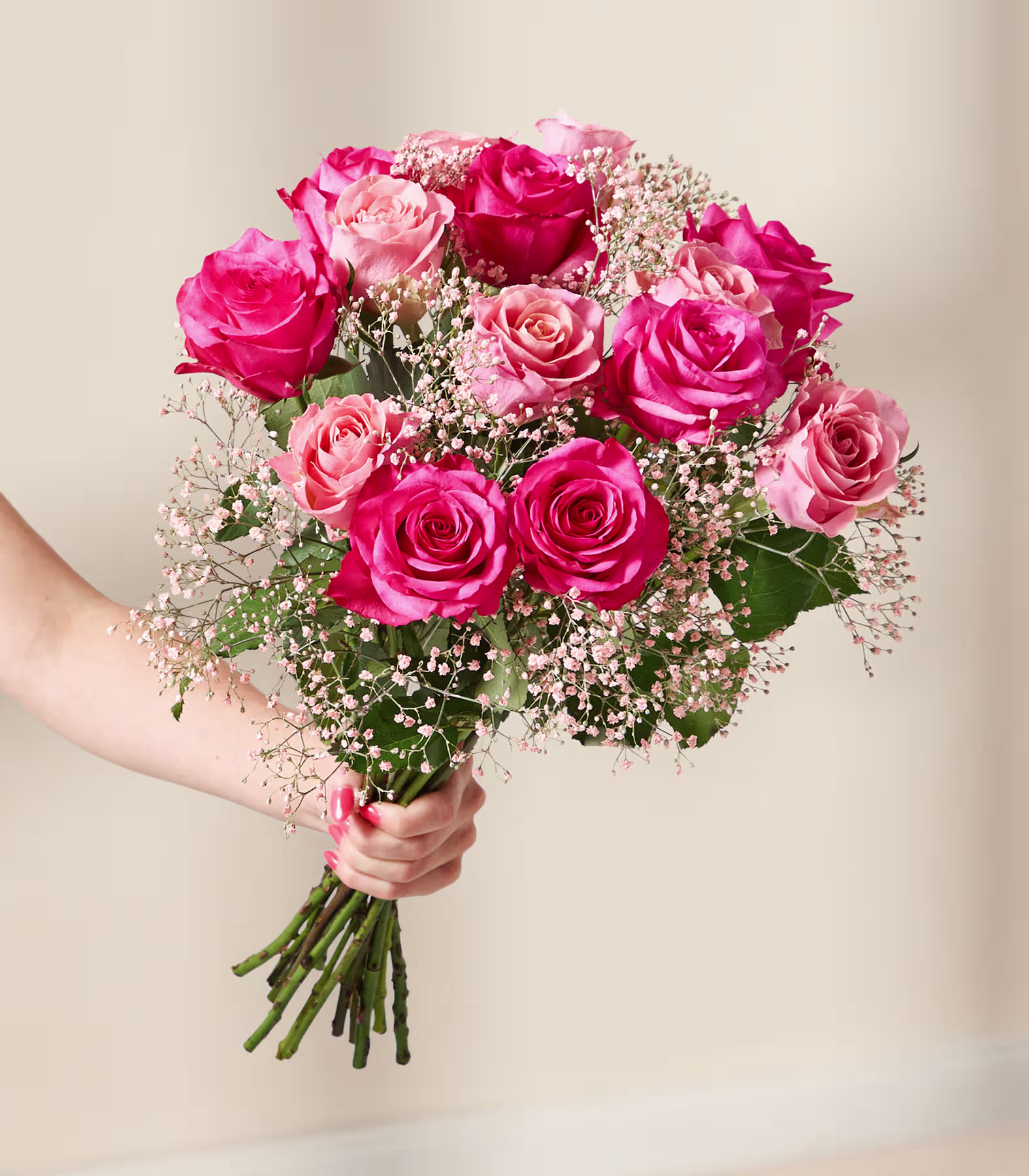 Ein lebendiger Strauß üppiger, samtiger roter und rosafarbener Rosen, umgeben von zarten Schleierkrautblüten, vor einem weichen, verschwommenen Hintergrund. (Beschreibungstext KI-generiert)