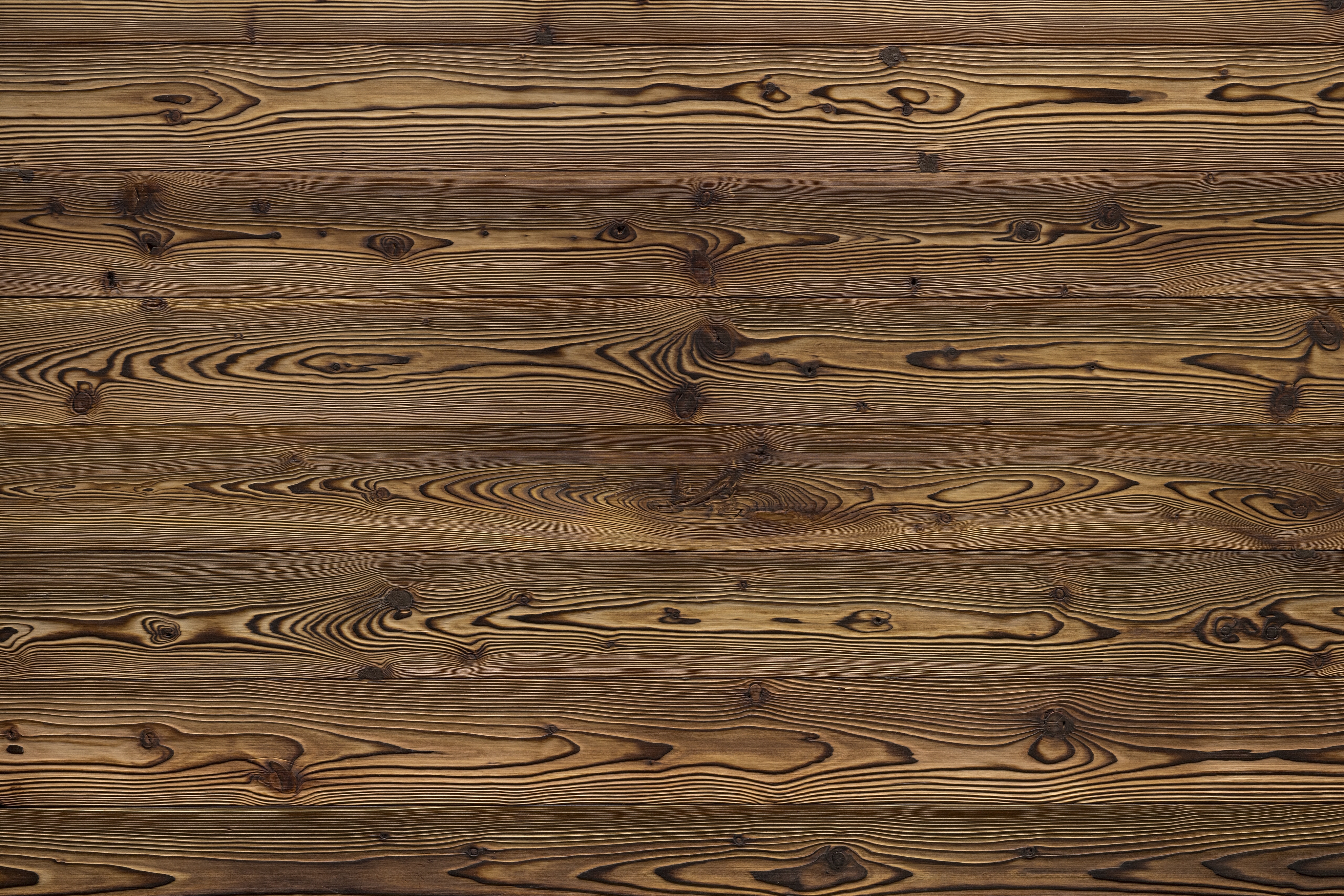 Les lambris (panneaux muraux et de plafond) de X-Wood sont synonymes d'une finition haut de gamme du bois et d'un concept de design qui intègre des matériaux naturels dans l'architecture moderne. Les panneaux portent souvent le nom de sommets de montagne célèbres (tels que le Cervin, l'Eiger ou la Marmolada). Techniques de finition : X-Wood utilise des procédés traditionnels et innovants tels que le hachage, le brossage, le brûlage (flamage), la vaporisation ou les traitements thermiques (jusqu'à 215 °C) pour créer des textures et des nuances de couleurs uniques.