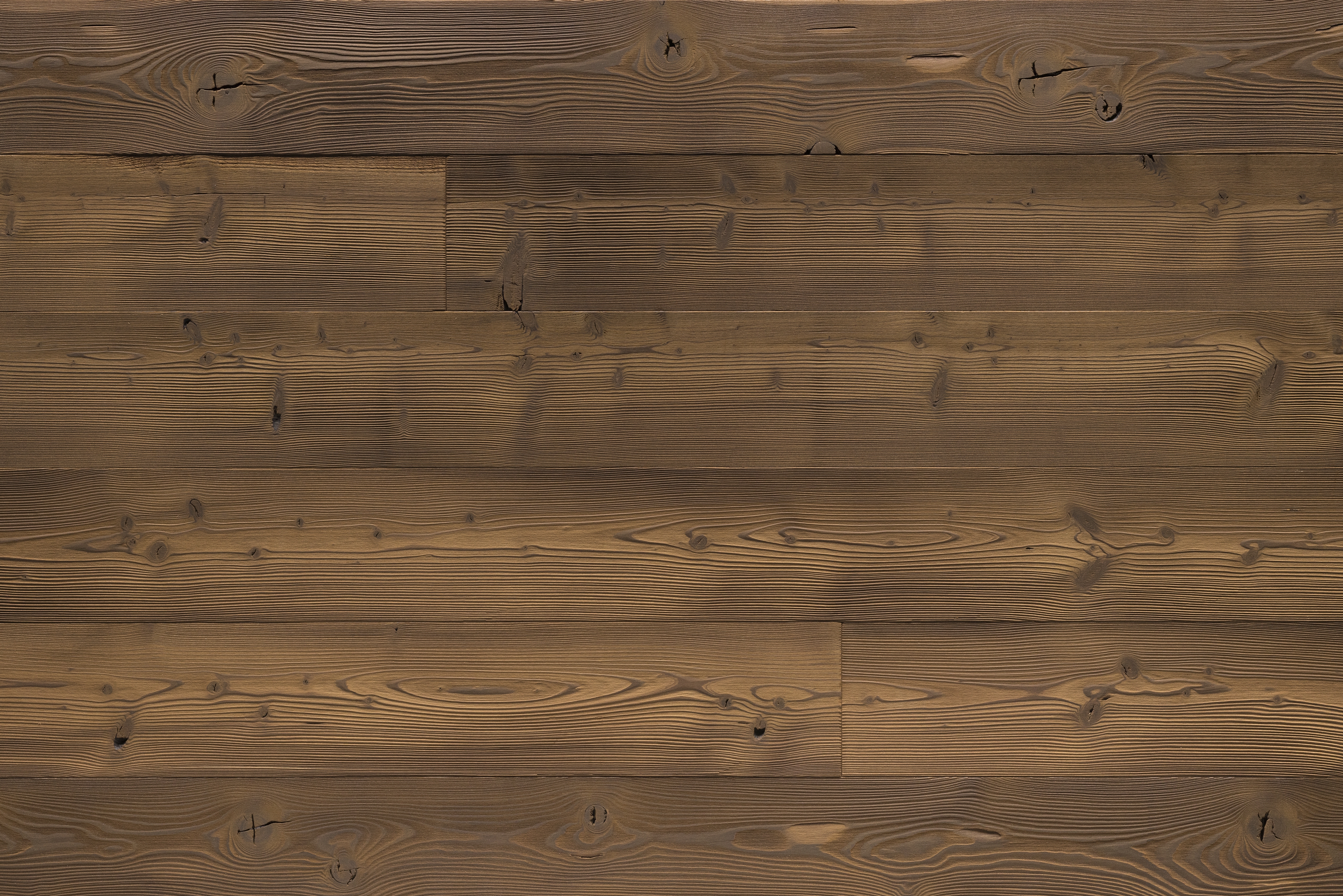 Les lambris (panneaux muraux et de plafond) de X-Wood sont synonymes d'une finition haut de gamme du bois et d'un concept de design qui intègre des matériaux naturels dans l'architecture moderne. Les panneaux portent souvent le nom de sommets de montagne célèbres (tels que le Cervin, l'Eiger ou la Marmolada). Techniques de finition : X-Wood utilise des procédés traditionnels et innovants tels que le hachage, le brossage, le brûlage (flamage), la vaporisation ou les traitements thermiques (jusqu'à 215 °C) pour créer des textures et des nuances de couleurs uniques.