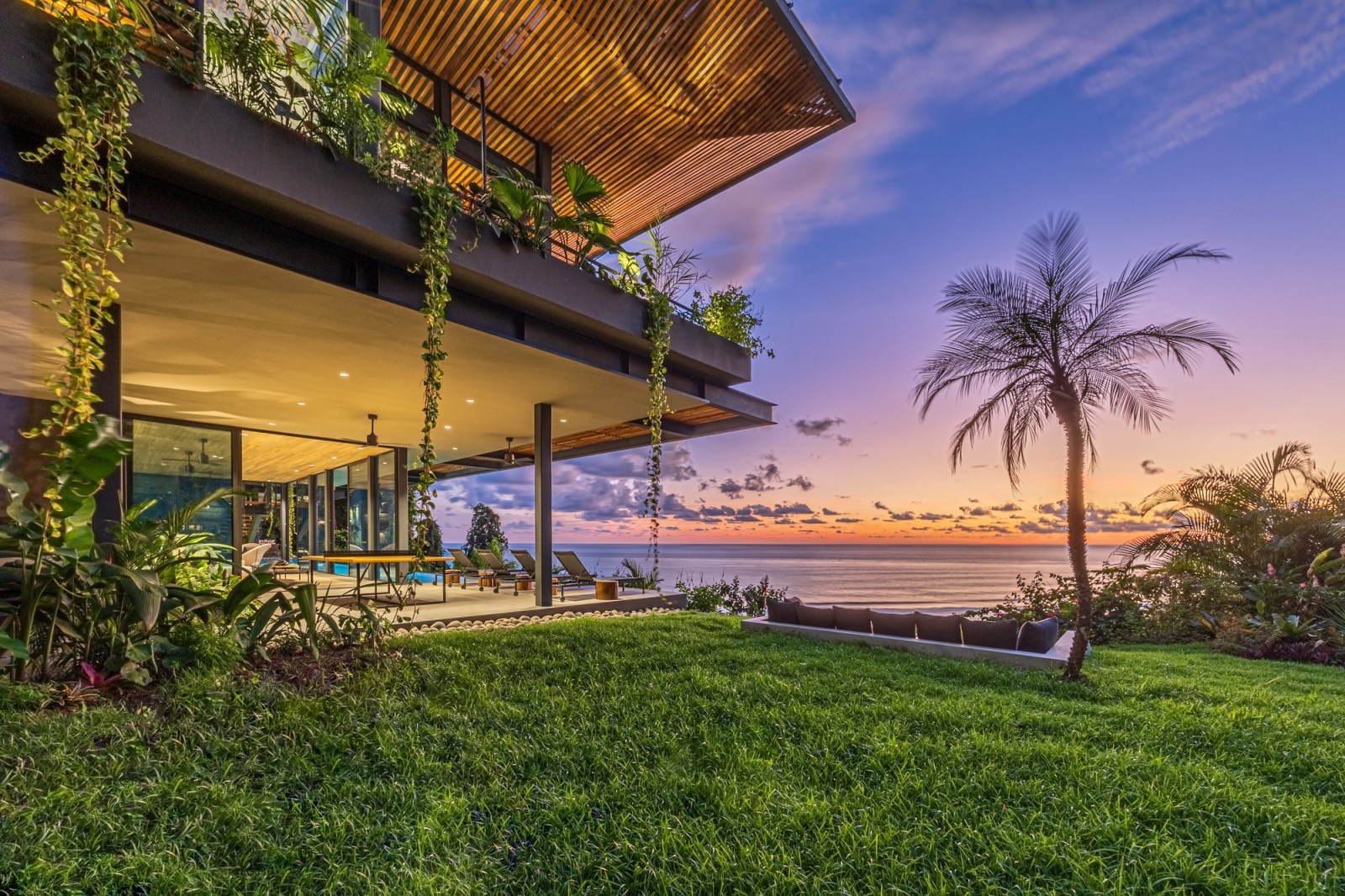 Luxury terrace with palm tree and ocean view during sunset in Costa Rica.