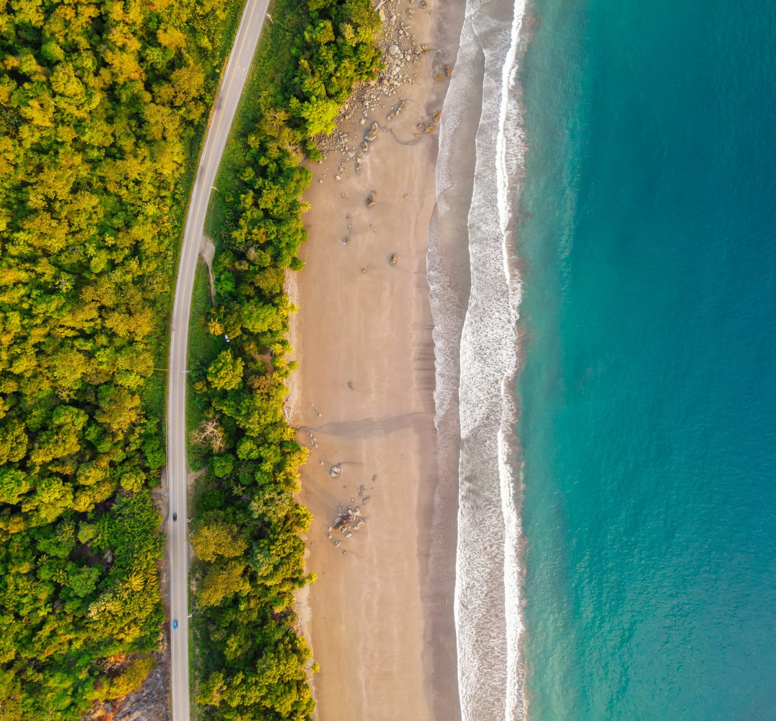 Aerial view of a coastal road winding through the jungle in Uvita.