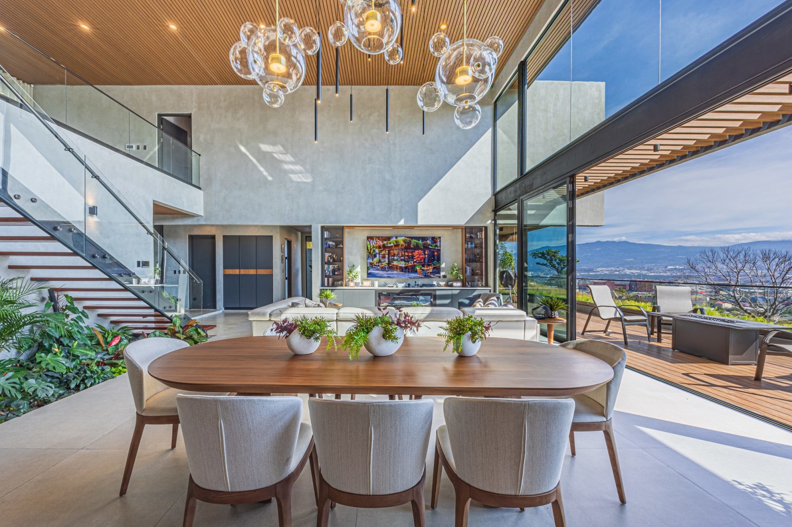 Designer dining area with mountain view, living room and deck in a luxury home.