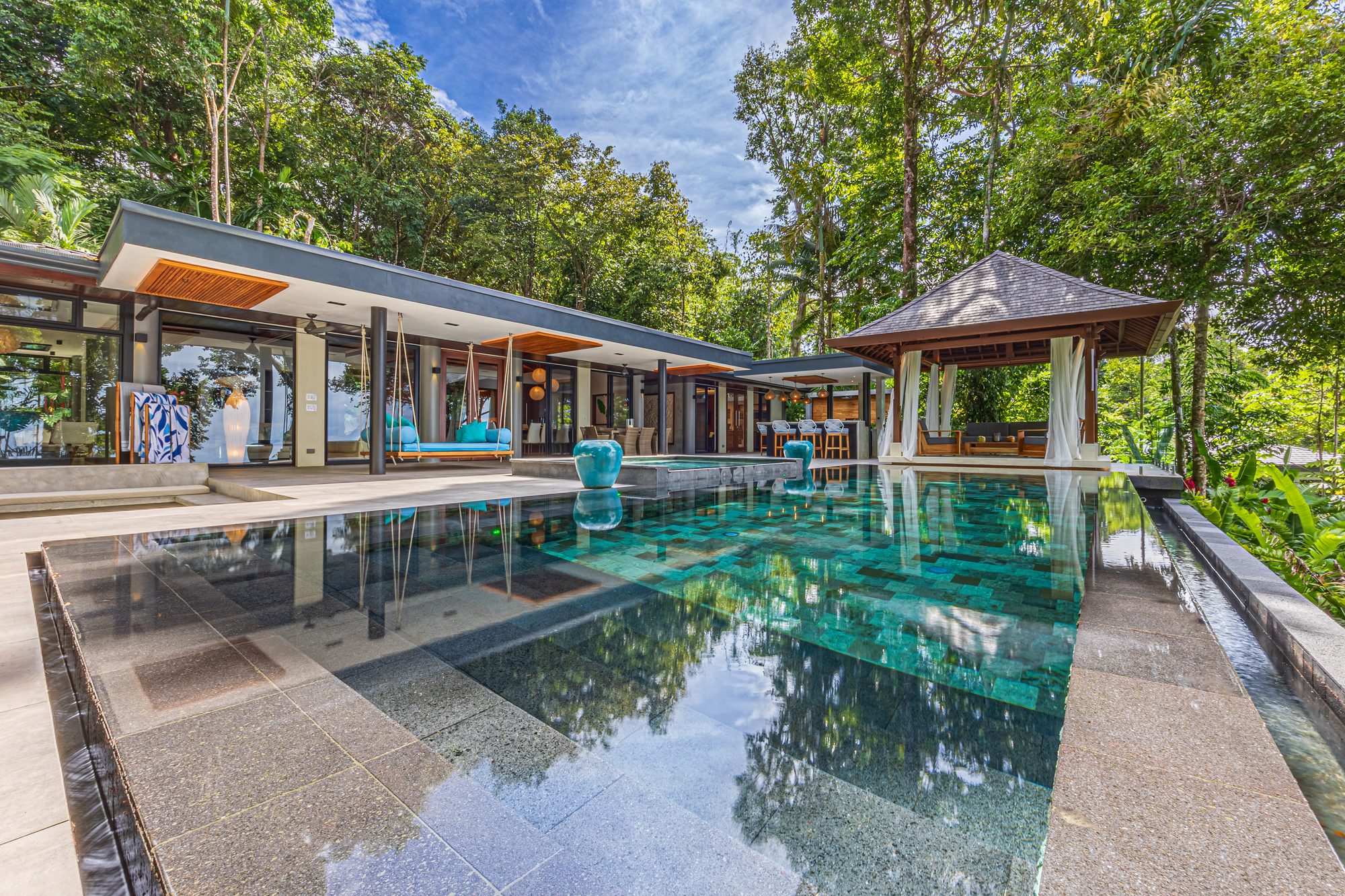 Luxury villa with infinity pool surrounded by tropical jungle.