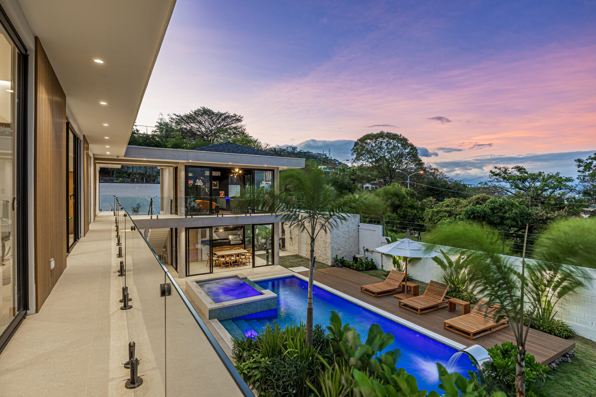Infinity pool with jacuzzi and deck at sunset overlooking the mountains.