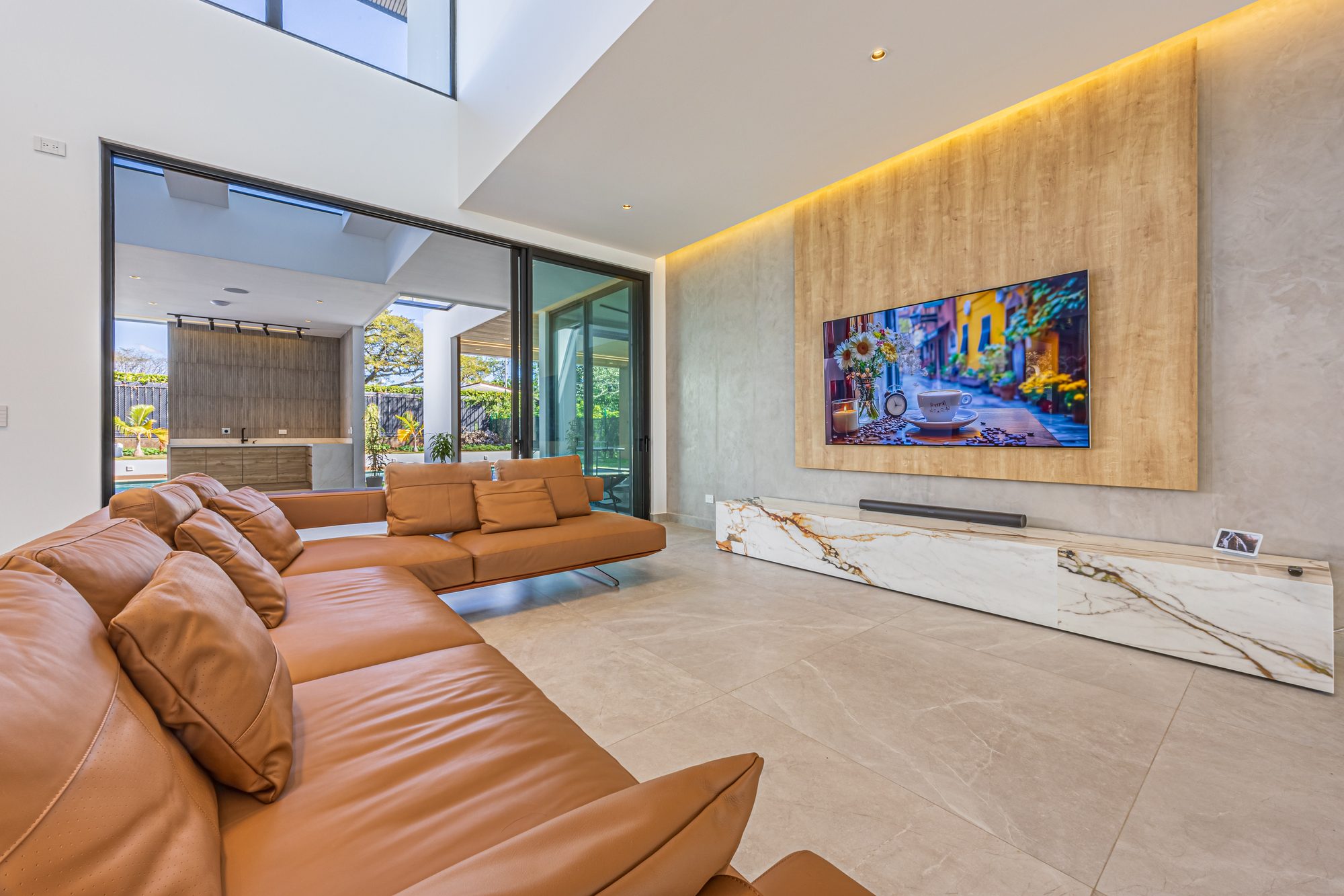Modern living room with leather sofa and wood accent wall with television.