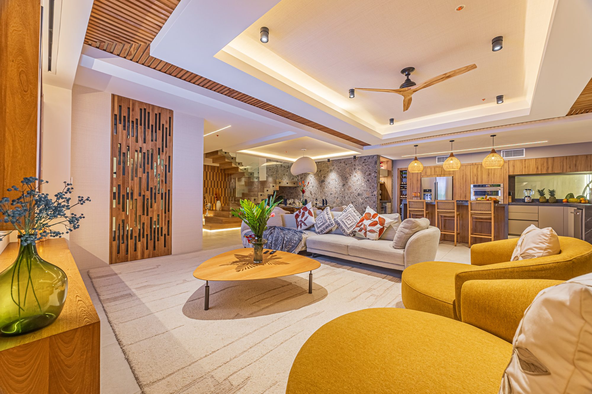 Spacious living room with open kitchen, sofas and wood accents.