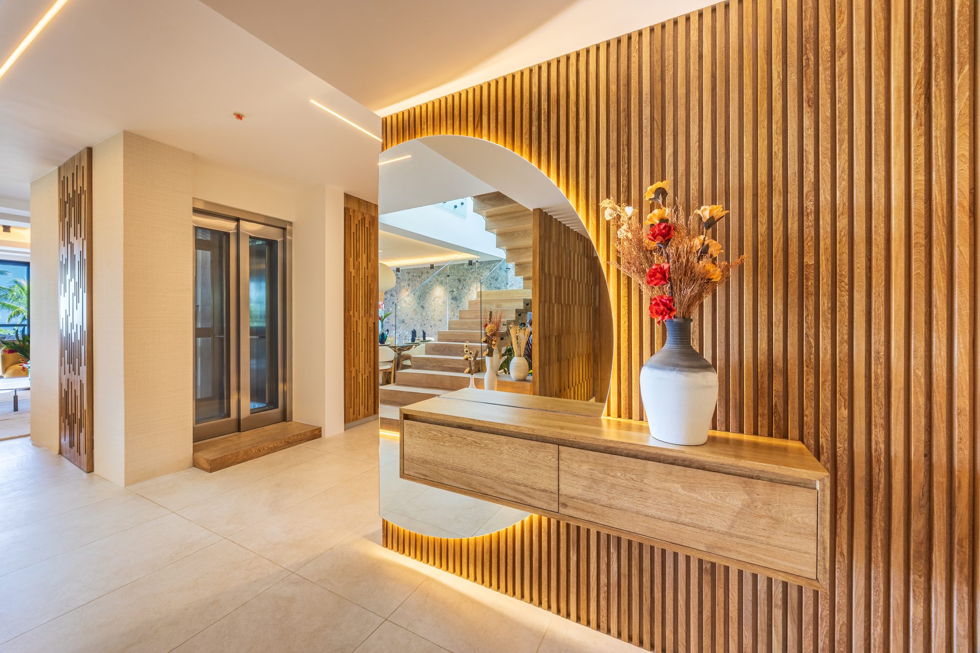 Entryway with a wood slat archway, floating console, and dried flower vase.