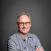 En profilbild av fastighetsmäklare Ola Claesson