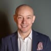 En profilbild av fastighetsmäklare Henrik Backman