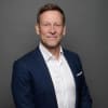 En profilbild av fastighetsmäklare Joakim Folkesson