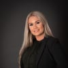 En profilbild av fastighetsmäklare Alexandra Mokos