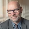 En profilbild av fastighetsmäklare Mikael Johansson
