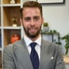 En profilbild av fastighetsmäklare Emanuel Turgay
