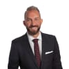 En profilbild av fastighetsmäklare Makis Batsoulis