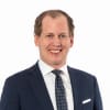 En profilbild av fastighetsmäklare Johan Arbenäs