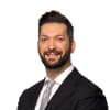 En profilbild av fastighetsmäklare Ilker Cengiz