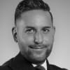 En profilbild av fastighetsmäklare Michael Kaya