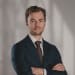 En profilbild av fastighetsmäklare Alex Adeheimer
