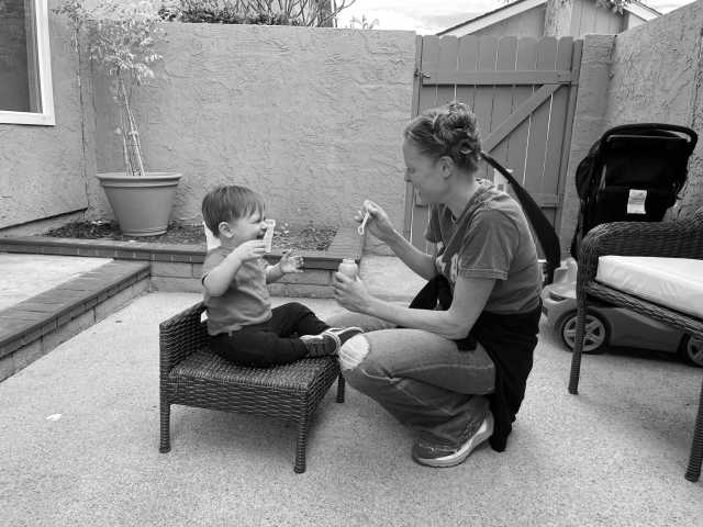 Doula blowing bubbles with toddler