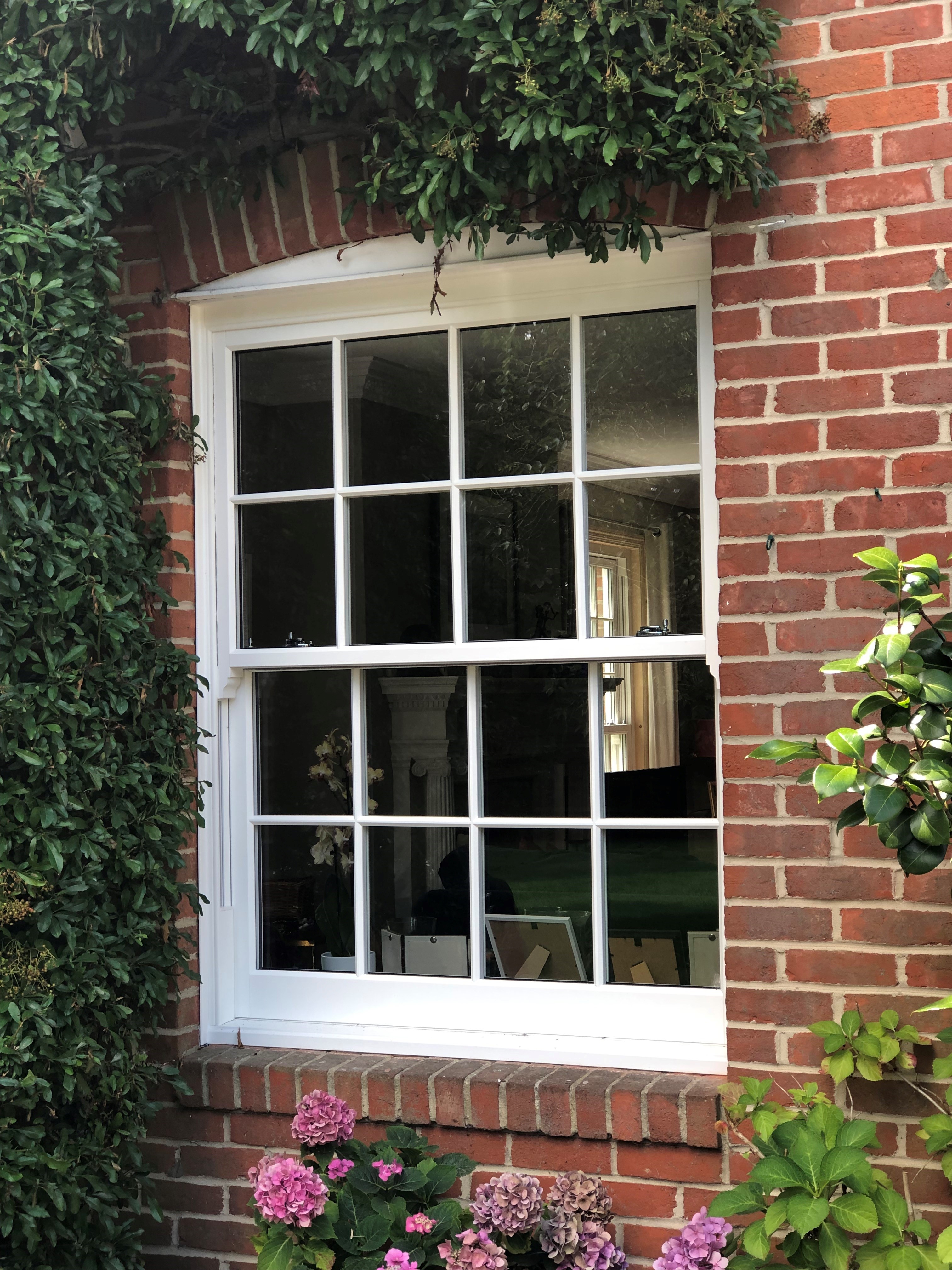 https://res.cloudinary.com/boxcleversashwindows/image/upload/v1700225276/website/images/latest-work/2023-08-detached-house-north-hampshire/Masterframe_Bygone_Harmony_Sash_Windows_with_Georgian_Bar_Grid.jpg