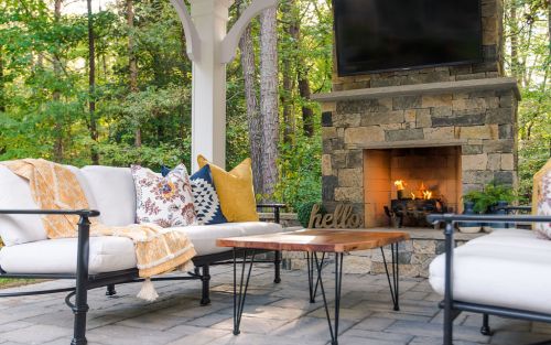 Paver patio with wood burning outdoor fireplace and outdoor television