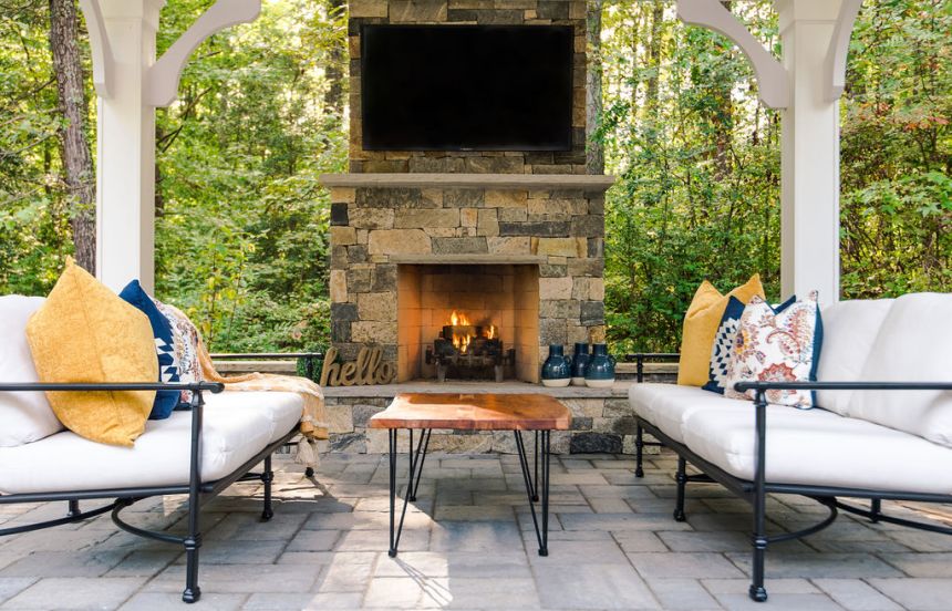 Paver patio with wood burning outdoor fireplace under a pvc pavilion