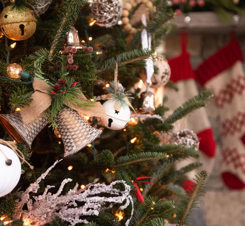 Bell ornaments are featured on this fully decorated christmas tree