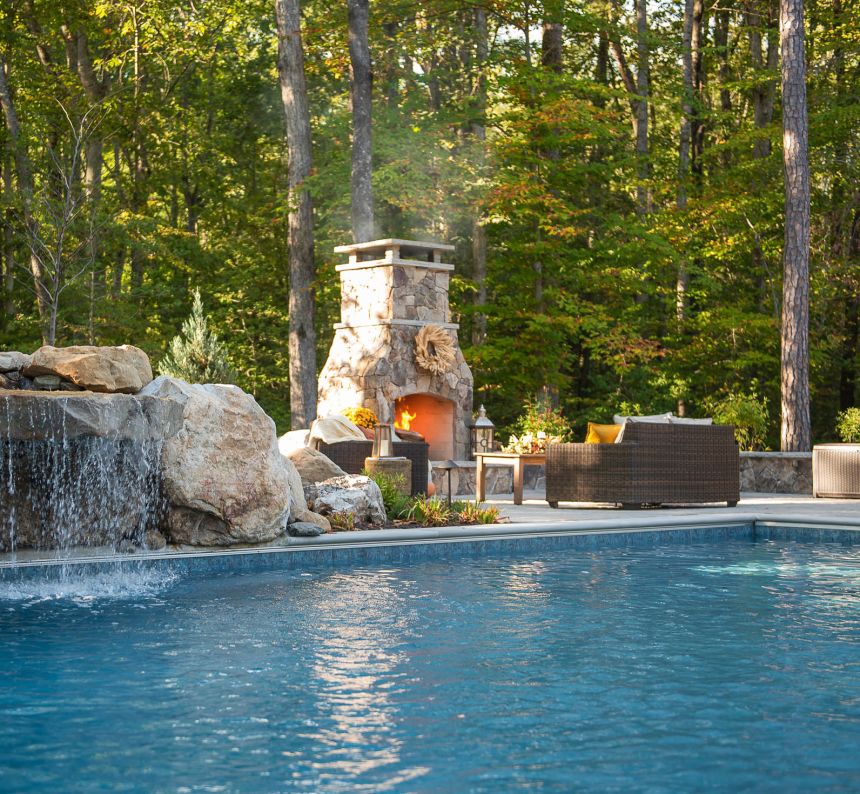 Gunite swimming pool with natural waterfall and outdoor fireplace