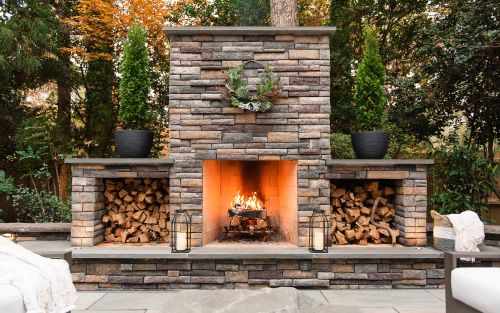 Stone outdoor fireplace with wood boxes