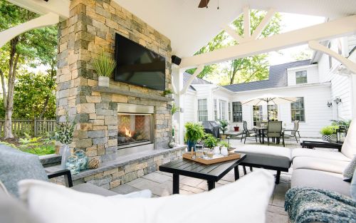 Gas burning outdoor fireplace under a white pavilion