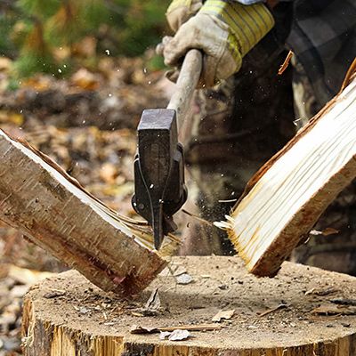 two hands and an axe chopping wood