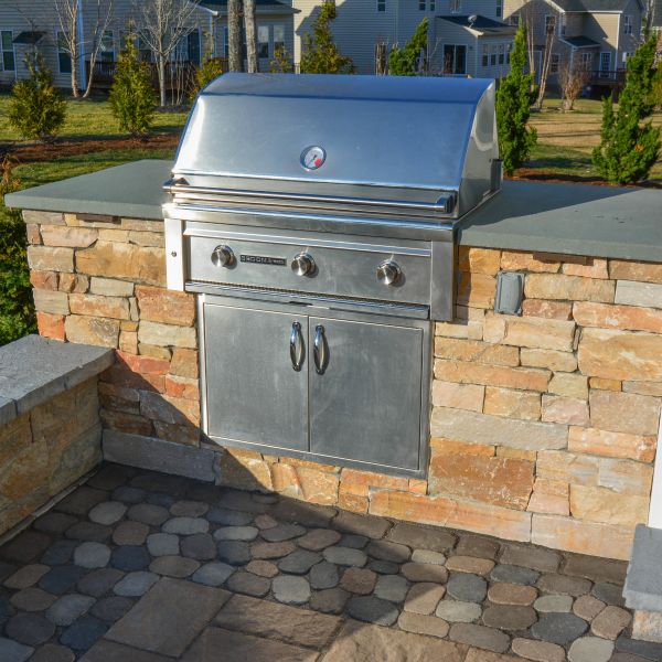 Outdoor grill with adjacent segmented wall