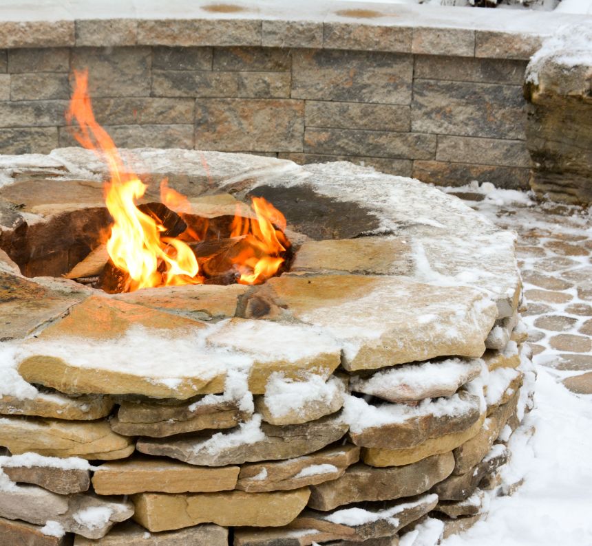 roaring fire inside the stacked stone veneer wood burning fire pit