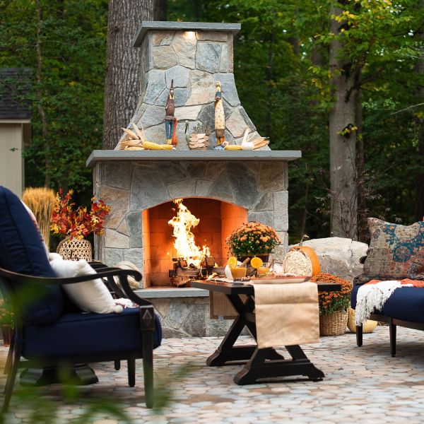 Beautiful sone outdoor fireplace with large mantle decorated for the fall