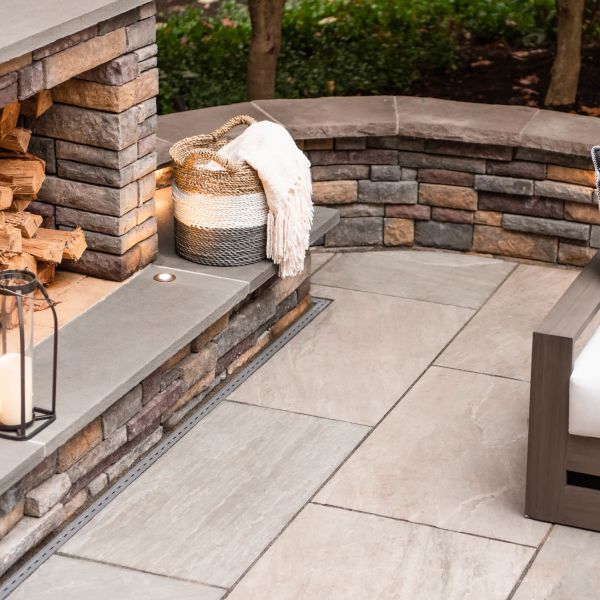 Natural Stone patio surrounded with a stacked stone veneer knee wall and fire place