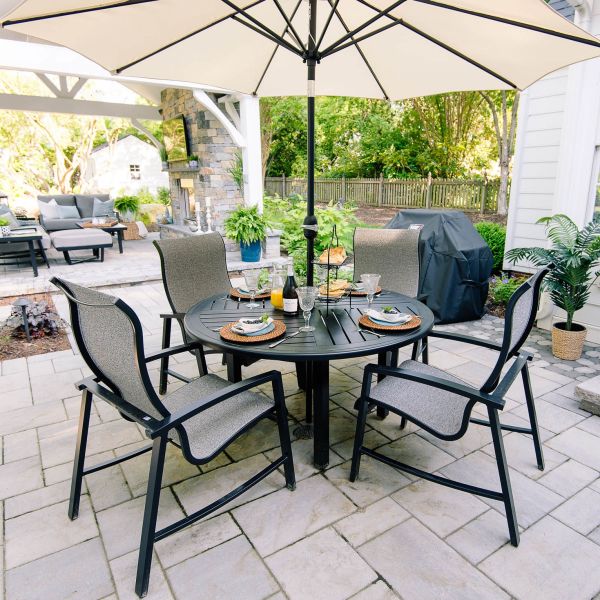 Patio table and chairs under an umbrella on the stone patio