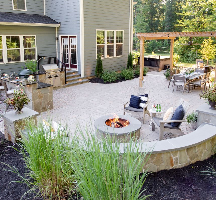 Paver patio with fire pit, pergola, outdoor kitchen, stone walls and landscaping