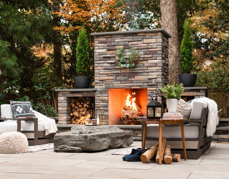 Outdoor Fireplace with wood boxes on a stone patio