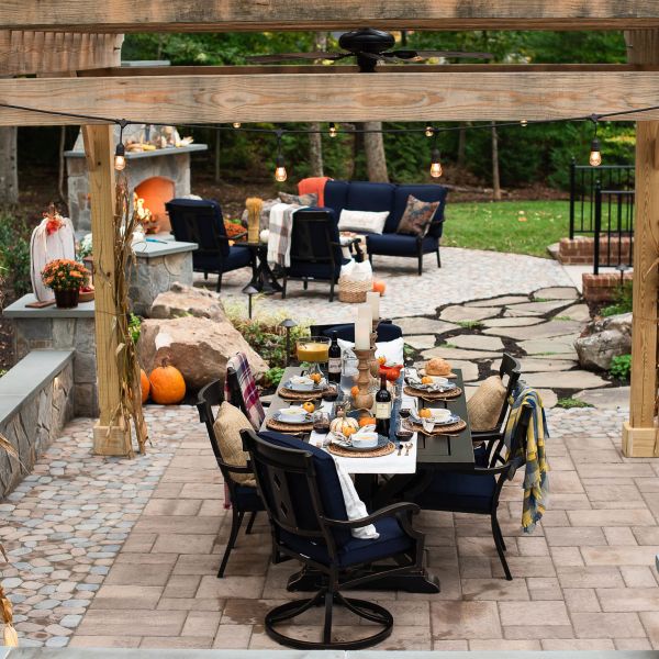 Outdoor dining table under a large pergola on patio