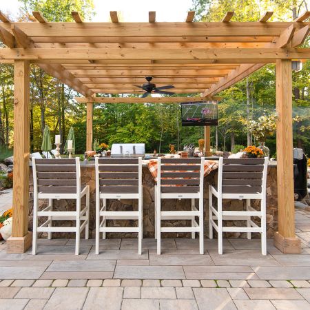this pergola with a fan installed offers shade to the outdoor kitchen and bar seating