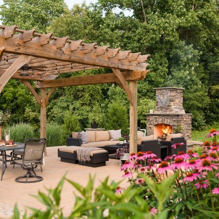 this rustic, tuscan-like backyard hosts a pergola, fireplace and lounge area