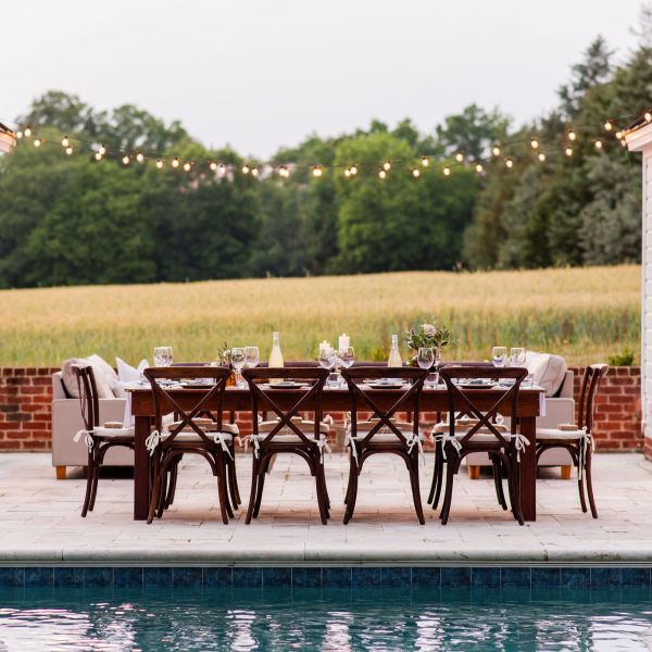 Elegant dinner party next to pool with travertine pool decking and cabanas