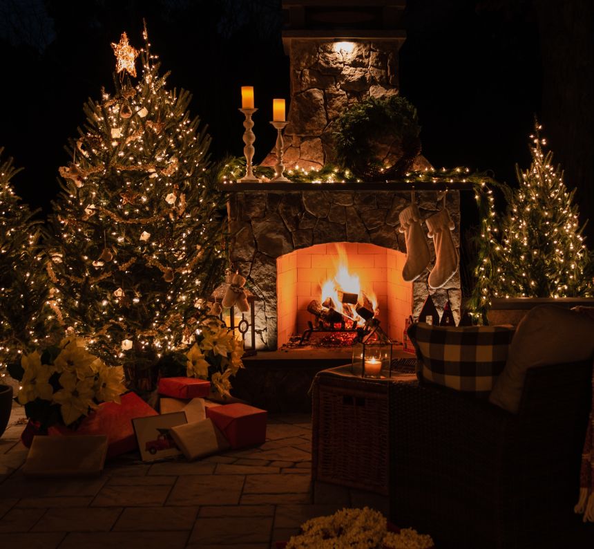 Fire in the large fireplace and lights on the Christmas tree light up the night