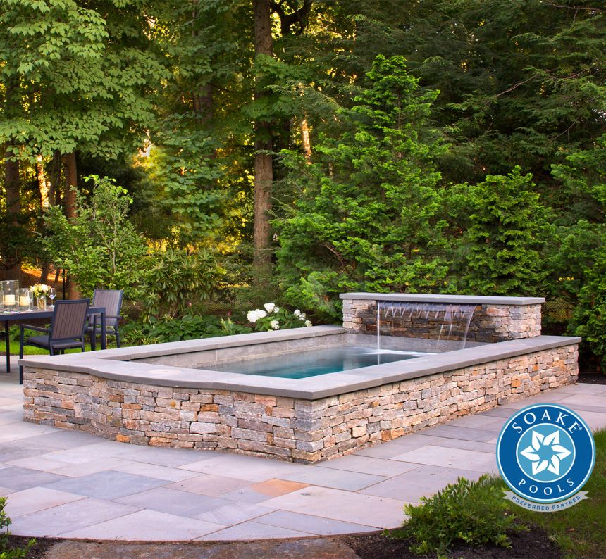 Soake plunge pool raised with stone veneer wall, fountain and stone patio