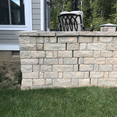 stone sitting wall shows the stones settling apart from each other and slightly crumbling
