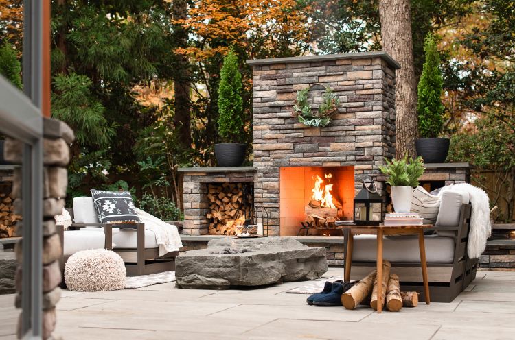 Landscaped backyard with pavers built around a fire pit