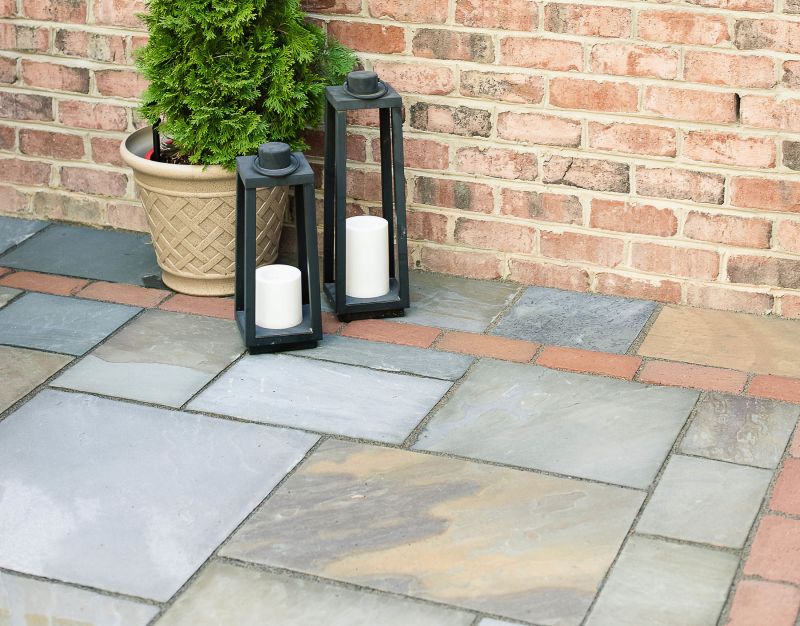 Bluestone patio with brick border and potted plants