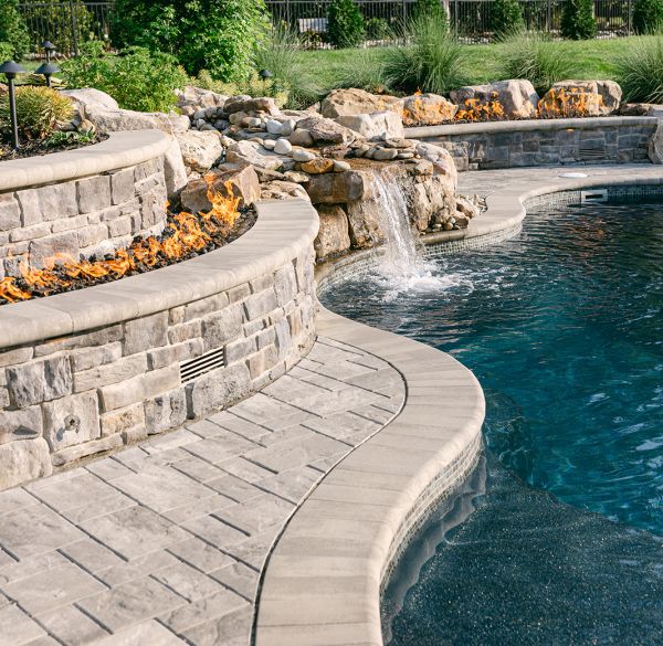 Gunite fiberglass swimming pool with sofa and stone wall
