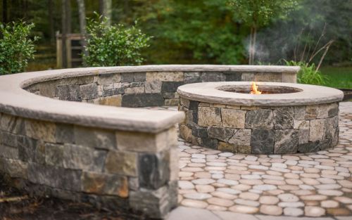 Paver patio with stone sitting wall and stone fire pit